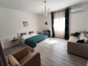 a bedroom with a bed and a couch at B&B Puvogel in Porticello