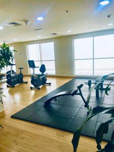 a gym with treadmills and chairs in a room at Ayo’s apartment in Dubai