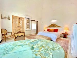 a bedroom with a large bed and a room with a bed sqor at Lella Kmar B&B avec piscine Sidi Bou Said in Sidi Bou Saïd