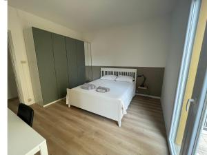 - une chambre avec un lit blanc et des armoires vertes dans l'établissement Casa Bea & Stefi, à Padoue