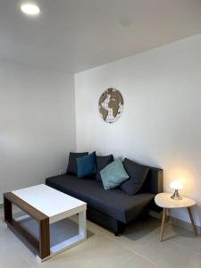 a living room with a couch and a table at Appart’ Cosy (E) proche Paris/Roissy CDG in Tremblay En France
