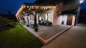 a patio with lights on a house at night at Hotel & Restauracja Wróblewscy in Karniewo