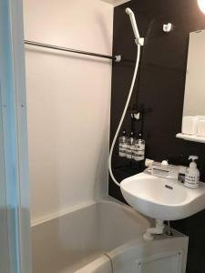 a white bathroom with a sink and a bath tub at Shinagawa New Apt Easy access to both Haneda & Narita Airport in Tokyo