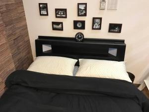 a bedroom with a black bed with pictures on the wall at Shinagawa New Apt Easy access to both Haneda & Narita Airport in Tokyo