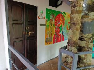 a room with a door and a painting on the wall at Anandam Woods - A Heritage single Room for couple-small family in Vaikom
