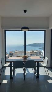 a dining room with a table and chairs and a large window at Modern Top Floor Sea View 3BR with Pools, Spa & Fitness in Becici