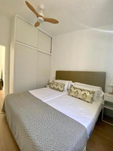 a bedroom with a white bed with a ceiling fan at Renovated nice private bungalow in Playa del Ingles +26 photos