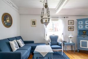 a living room with blue furniture and a chandelier at Reetdachhaus Ohl Dörp in Wyk auf Föhr