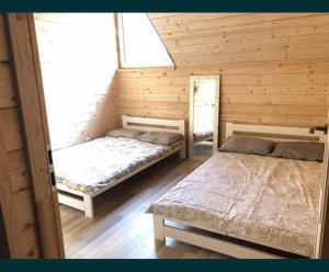 1 Schlafzimmer mit 2 Betten in einer Holzhütte in der Unterkunft Sielanka Mazurska Świętajno in Świętajno