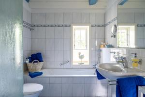 a bathroom with a tub and a sink and a toilet at Reetdachhaus Ohl Dörp in Wyk auf Föhr +57 photos