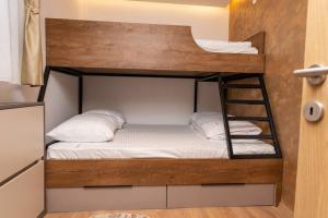 łóżko piętrowe z białą pościelą i poduszkami w obiekcie Villa Selzo lux w mieście Pale