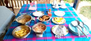 una mesa azul cubierta con platos de comida en una mesa en ilkerin camp maasai mara, en Sekenani