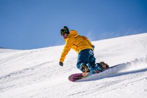 a man riding a snowboard down a snow covered slope at B&B Sissi in Commezzadura