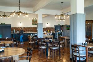 a restaurant with wooden tables and chairs and a woman in the background at Hotel BellaVista in San Carlos de Bariloche +49 photos