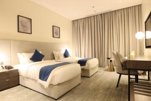 Cette chambre comprend deux lits et un bureau. dans l'établissement فندق سافوي جدة Savoye Hotel, à Djeddah