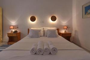 a bedroom with a bed with three towels on it at Pansion Prodromina in Skopelos Town