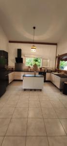 a large kitchen with a table in the middle of a room at VILLA CAJOU DESIRADE in Baie Mahault