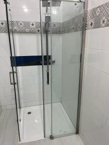 y baño con ducha y puerta de cristal. en House of Flora, en Saint-Louis