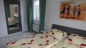 a bedroom with a bed with red flowers on it at FEWO-bis-2-Pers-inmitten-den-Yachthafens-Ueckermuende-Stettiner-Haff-Ostsee in Ueckermünde