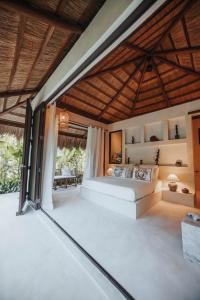 a living room with a bed and a large window at ALON Villas in El Nido