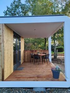 - un pavillon avec une table et des chaises sur une terrasse en bois dans l'établissement Vakantiewoningen Eyveld, à Beesel