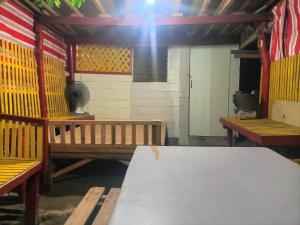 a room with benches and a table and a stove at Ramos Family Patungan Beach in Maragondon