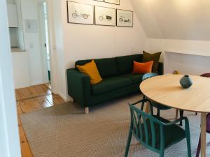a living room with a green couch and a table at Quiet apartment in Copenhagen