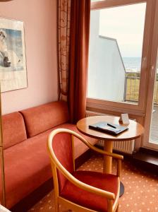 Zimmer mit einem Sofa, einem Tisch, einem Tisch und einem Fenster in der Unterkunft Hotel Germania in Bansin