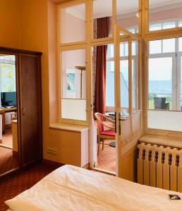 a bedroom with a bed and a view of the ocean at Hotel Germania in Bansin