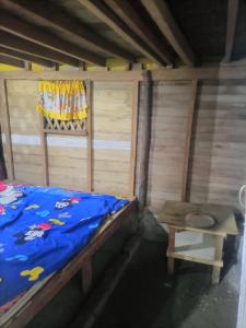 a small bedroom with a bed and a table at Ramos Family Patungan Beach in Maragondon