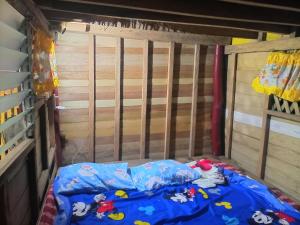 a bed in a room with a wooden wall at Ramos Family Patungan Beach in Maragondon