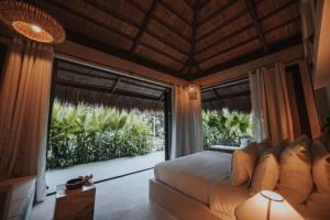 a bedroom with a bed and a large glass door at ALON Hotel in El Nido