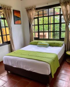 a bed in a room with a large window at Casas De Campo - El Paraíso in La Vega