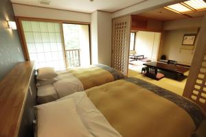 Postel nebo postele na pokoji v ubytování Kinseikan Seseragi