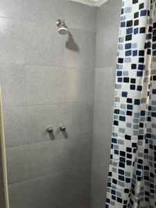 a bathroom with a shower with a shower curtain at Furnished self catering cottage in Lusaka