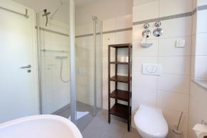 une salle de bain avec toilettes et douche en verre dans l'établissement Strandstrasse 21 Ferienwohnung Domizil Auszeit, à Kolpinsee 14 autres photos