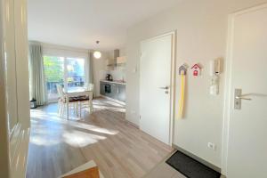 une pièce avec une cuisine avec une table et un réfrigérateur dans l'établissement Strandstrasse 21 Ferienwohnung Domizil Auszeit, à Kolpinsee