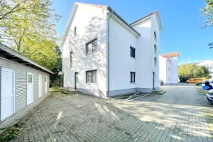 une vue extérieure d'une maison blanche avec une allée dans l'établissement Strandstrasse 21 Ferienwohnung Domizil Auszeit, à Kolpinsee