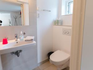 a white bathroom with a toilet and a sink at 2 quiet apartments in Copenhagen +18 photos