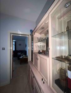 uma cozinha com armários de vidro e uma sala de estar em Private Room BeachFront Apartment em Portsmouth