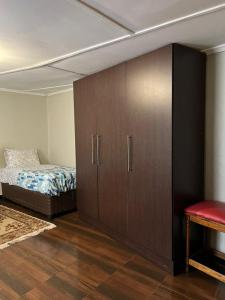 a room with a bed and a large cabinet at Furnished self catering cottage in Lusaka