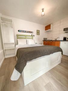 um quarto com uma cama grande e uma cozinha em Little Place Nazaré na Nazaré