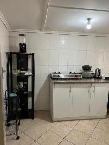 a kitchen with a counter and a stove in it at Furnished self catering cottage in Lusaka
