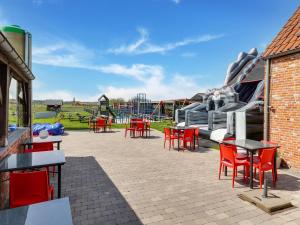 un parque infantil con sillas y mesas rojas y un tobogán de agua en In de Wollekjes en Merksplas