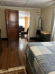 - une chambre avec un lit, un bureau et une chaise dans l'établissement Furnished self catering cottage, à Lusaka