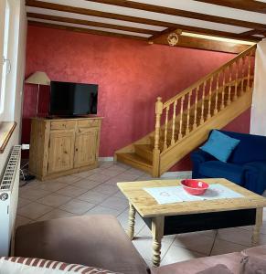 a living room with a couch and a table and a tv at Gite Du Rittersberg in Scherwiller