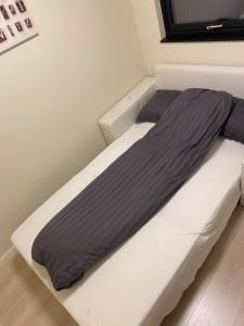 Rom # 2 Appartmenthotell Oslo Adress Isabels vei 16 في أوسلو: غرفة نوم مع سرير مع لحاف رمادي