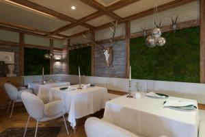 a dining room with two tables and chairs and a chandelier at Hotel Hirzer 2781 in Avelengo