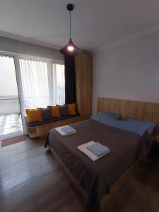 une chambre avec deux lits et une grande fenêtre dans l'établissement Cosy Apartment, à Bordjomi 16 autres photos