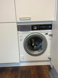 a washing machine in a cabinet in a kitchen at Basel-Stadt Gundeldingen Zimmer 403, WC in the hallway, outside the room in Basel